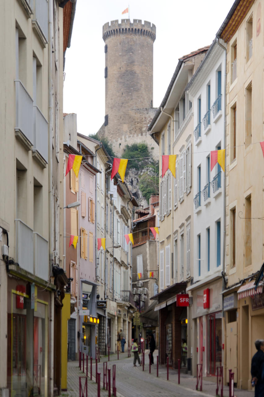 Photo d'une rue de Foix avec une vue sur la tour du château.